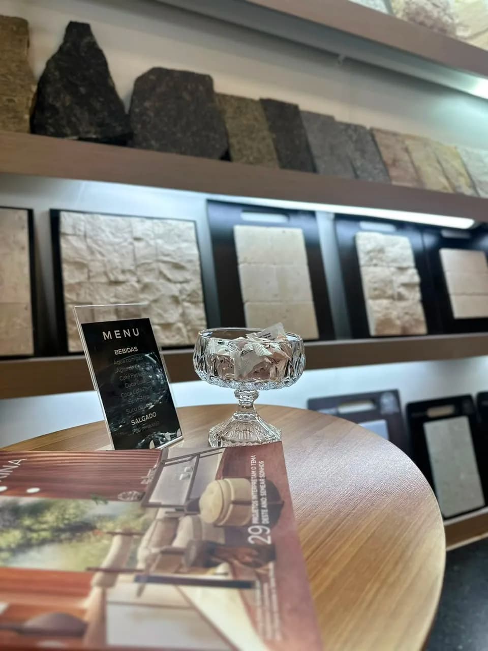 Mesa com amostras de pedra, menu e taça de cristal
