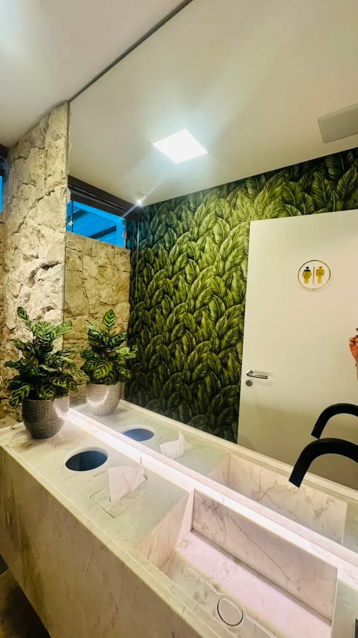 Lavabo com parede verde e bancada de pedra